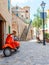 Vintage red motor scooter parked in historic spanish village