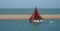 Vintage Red sailed Yacht entering the river Deben estuary at Felixstowe Ferry.