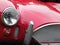 vintage red sports car detail showing grill, headlights and chro