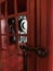 Vintage red telephone booth with aged retro wall hanging dial phone inside. Old-fashioned decoration, furnishing design concept