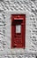 Vintage red UK postbox set in a white wall