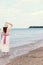 Vintage redhead woman at the beach wearing straw hat