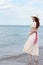 Vintage redhead woman wearing hat at the ocean