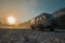 Vintage retro campervan parked on the wild camping ground next to a river at early hazy morning hours. Adventure time for campers