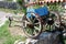 Vintage retro dilapidated part of wooden horse carriage with metal wheel frames used as garden decoration for planting flowers in