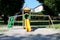 Vintage retro looking outdoor public playground equipment made of plastic slide with wooden swing and climbing wall surrounded