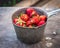 Vintage ripe strawberries from a rustic garden on a wooden bench outdoors