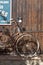 Vintage roasted bicycle near a wooden wall