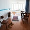 Vintage room with retro radio turntable, telephone and standart lamp, red cat resting on old fashioned armchair. Interior of 20th