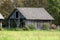 Vintage rustic old dilapidated wooden barn made from wooden boards with open area filled with hay bales for storage over winter