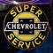Vintage rusty Chevrolet advertisement sign. American car brand owned by GM. White on black logo.