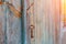 A vintage rusty key hangs on a nail on the wall of an old house, at dawn