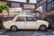 Vintage scrap Fiat 124 car parked in front of a shanty house in the ghetto of Hamamonu district, Ankara, Turkey