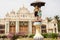 Vintage sculpture of boy and girl under an umbrella past historical Mysore building, Karnataka of India.