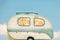 Vintage seventies white caravan in front of a blue sky with clouds