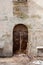 Vintage shabby house wall with rusty metal door closed. vertical view