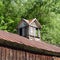 Vintage shuttered barn cupola sits on rustic tin roof