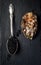 Vintage silver spoon with black sturgeon caviar and oyster on black slate stone background. Top view, flat lay, copy space.