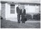 Vintage Snapshot: Tall man short man outside surburban house.