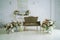 Vintage sofa and vases with flowers stand near the mirror