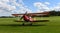 Vintage Stampe SV.4C, G-HJSS 1101 Biplane on airstrip grass with blue sky and clouds.