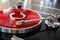 Vintage Stereo Turntable Record Player Tonearm Above Red Colored Vinyl