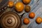 Vintage still life in dark colors. Iron kettle with oranges on scratched boards.