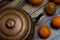 Vintage still life in dark colors. Iron kettle with oranges on scratched boards.