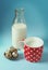 Vintage still life with red, in polka dot, cup of milk, quail eggs, and vintage glass bottle