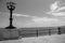 Vintage street lantern on seashore black and white. Boardwalk with street lamp monochrome. Coastline illumination.