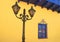Vintage Streetlamp against Tuscan Sun Yellow Wall with Royal Blue Colored Decorative Window