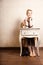 Vintage style. Barefoot girl sitting at retro desk