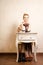 Vintage style. Barefoot girl sitting at retro desk