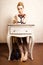 Vintage style. Barefoot girl sitting at retro desk