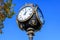 Vintage style black and grey metallic clock towards clear blue sky in Unirii Park Parcul Unirii, in Bucharest, Romania, in a