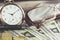 Vintage style finance concept with glasses, dollar bills, retro clock, coins and fountain pen. Selective focus