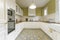 Vintage-style kitchen furnished in a u-shaped white lacquered wood with wooden countertop, white tiles and hydraulic tile floor