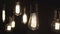 Vintage style light bulbs swinging on the wire in the home. Decorative lights at home. Old Edison bulb