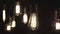 Vintage style light bulbs swinging on the wire in the house. Decorative lights at home. Old Edison bulb