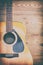 Vintage style photography of acoustic guitar on rough wooden background