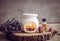 Vintage style picture of white ceramic candle aroma oil lamp with essential oil bottle and dry flower petals on natural pine wood