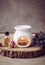 Vintage style picture of white ceramic candle aroma oil lamp with essential oil bottle and dry flower petals on natural pine wood