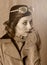 Vintage style portrait of aviator woman wearing goggles, leather jacket and scarf