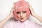 Vintage style portrait of beautiful woman in fancy pink wig touching her head