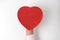 Vintage style red heart shaped box on mens palm. Close-up