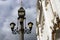 Vintage style street light across blue sky with clouds.