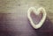 Vintage stylized heart made of shells on wooden background.