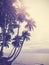 Vintage stylized tropical beach with palm tree at sunset