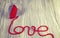 Vintage stylized wooden heart with red yarn love sign.