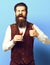 Vintage suede leather waistcoat on blue studio background, funny handsome bearded man